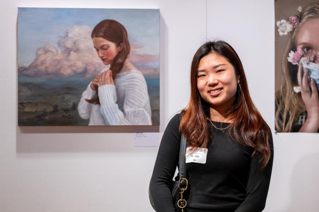 Student artist posed in front of her painting at the High Museum