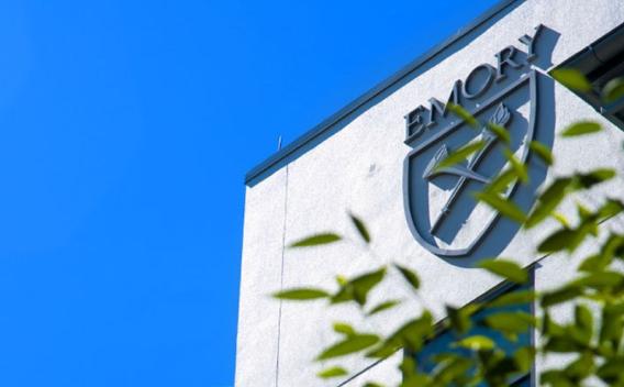 Top of campus building adorned with the Emory shield