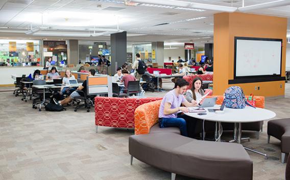 A busy Woodruff Library common area with tables and couches