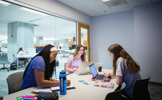 Three female students working in a reservable study space