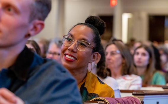 Woman listening and smiling in the audience during an event