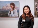 Student artist posed in front of her painting at the High Museum